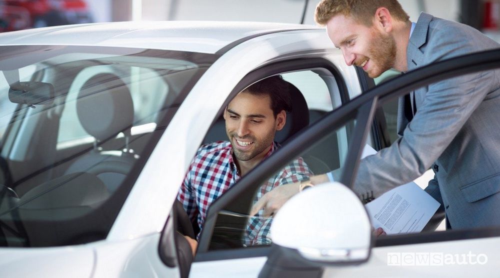 smiling man behind the wheel with plaid shirt taking instructions