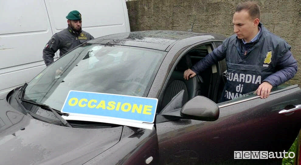 Due agenti della Guardia di finanza nell'atto di confiscare un'auto rubata Guardai di finanza che smaschera un'auto rubata