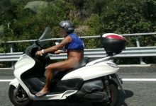 Uomo nudo sullo scooter in autostrada