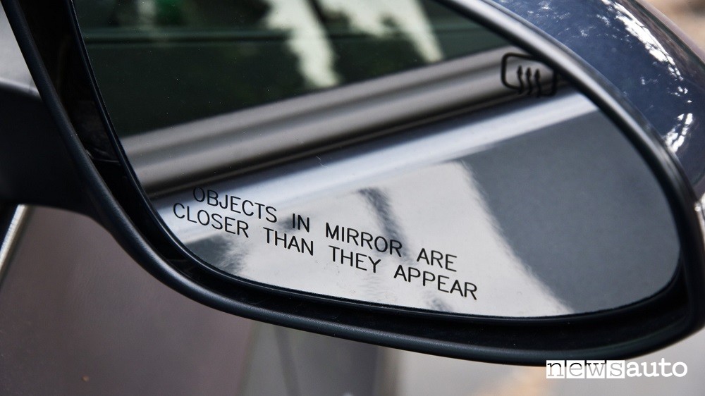 Specchietto retrovisore montato su una vettura americana che recita "gli oggetti nello specchietto sono più vicini di quanto sembra"