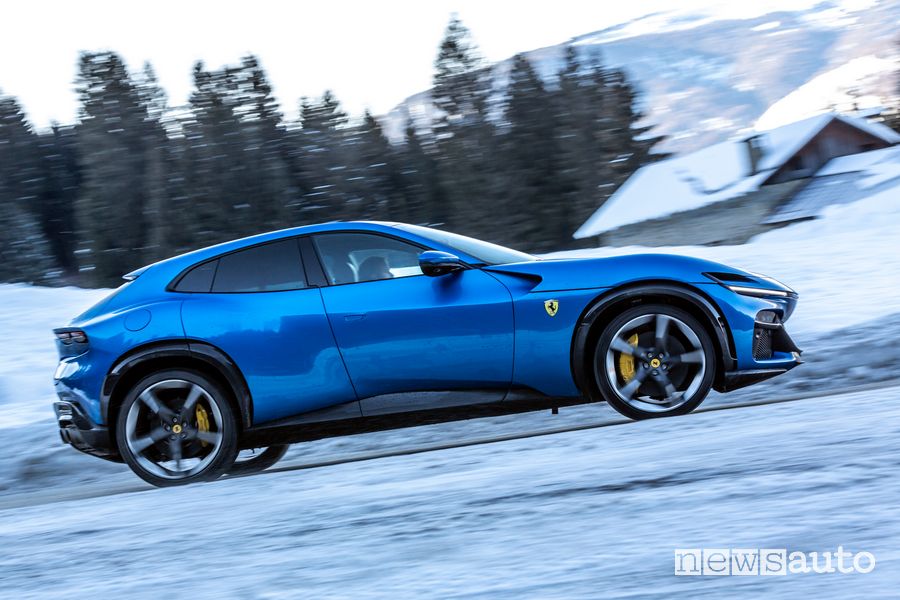 Ferrari Purosangue blu laterale in movimento sulla neve